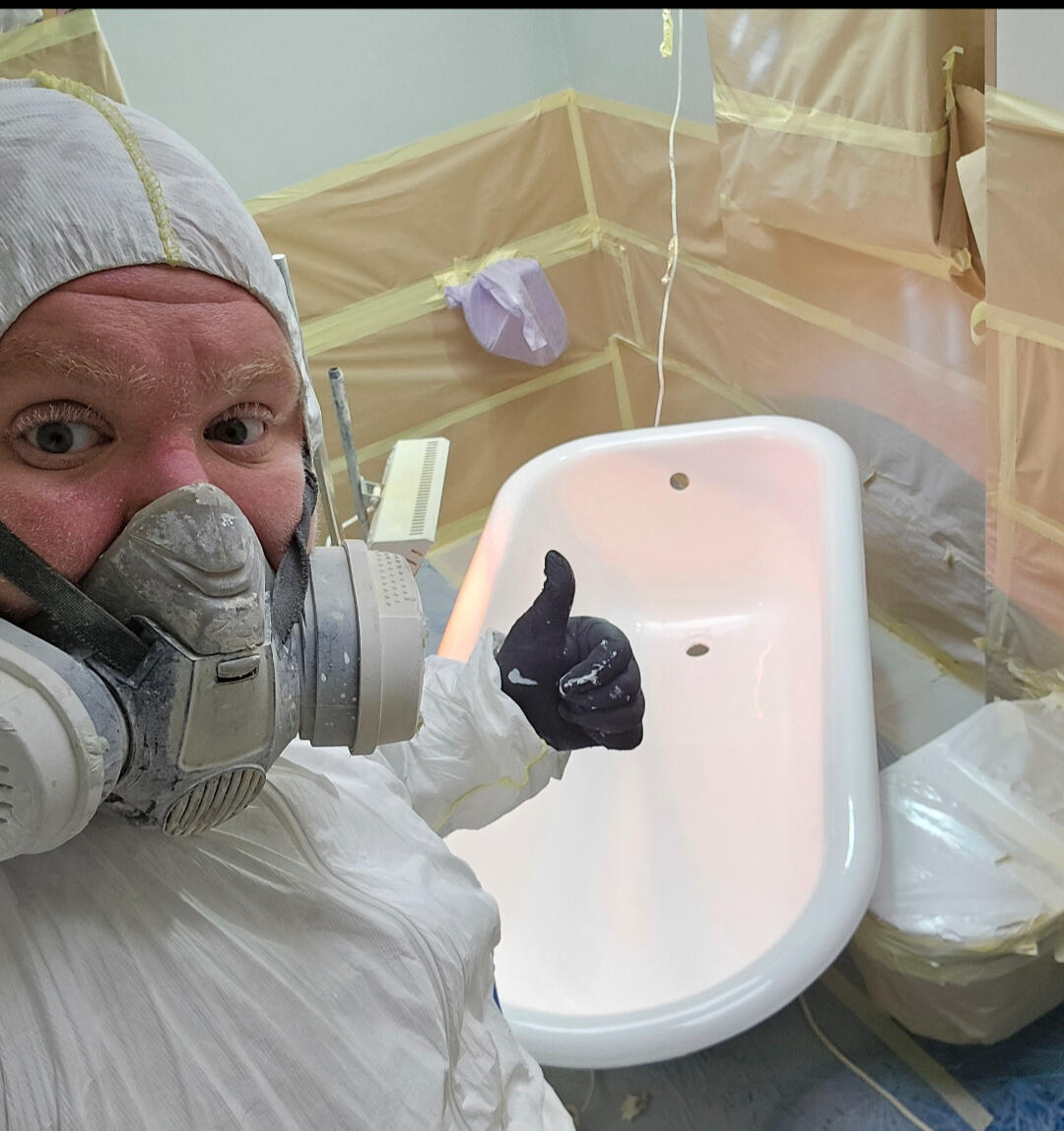 photo of glossy baths re-enamelling owner Seamus with a thumbs up, in ppe, in a room full of masking up and a completed bath in Solihull